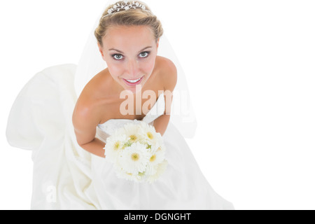 Fröhliche blonde Braut hält einen Blumenstrauß Stockfoto