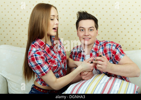 Porträt eines jungen Paares mit Fernbedienung vor Fernseher Stockfoto