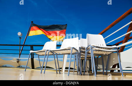 Deutsche Flagge hinter leeren Stuhlreihen auf der Rückseite von einem Ausflugsschiff, Berlin Stockfoto