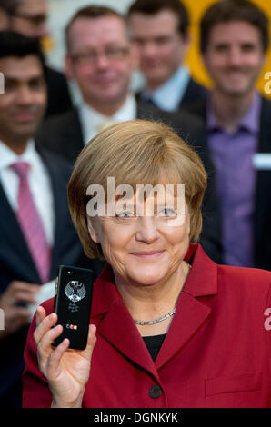 Hannover, Deutschland. 5. März 2013. Bundeskanzlerin Angela Merkel präsentiert eine abhörsichere Handy BlackBerry an einem Stand von Secusmart während der Eröffnung Runde Tour der weltweit größte Computer-Messe CeBIT in Hannover, Deutschland, 5. März 2013. Merkel erhält ein neues offizielles Handy und Blackberry sowie ein Smartphone von Samsung sind auf den ausgewählten. Foto: JULIAN STRATENSCHULTE/Dpa/Alamy Live News Stockfoto