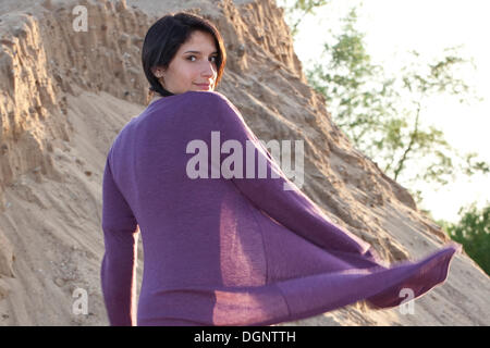 Junge Frau tanzen vor einer Sanddüne an einem Baggersee Stockfoto