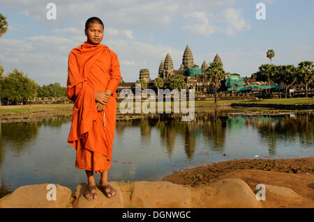 Buddhistischer Mönch vor der Tempelanlage Angkor Wat, mit Spiegelbild im Wasser, Siam Reap, Kambodscha, Südost-Asien Stockfoto