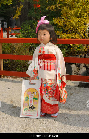 Mädchen tragen einen festlichen Kimono am Shichi-Go-San-Festival oder sieben-fünf-drei Festival, hält sie eine typische Chitose-Ame Stockfoto