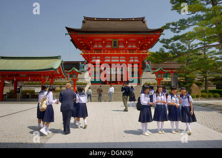 SchülerInnen stehen vor dem Torhaus von Fushimi Inari-Taisha Shinto-Schrein, Fushimi, Kyoto, Kinki-Region, Japan Stockfoto