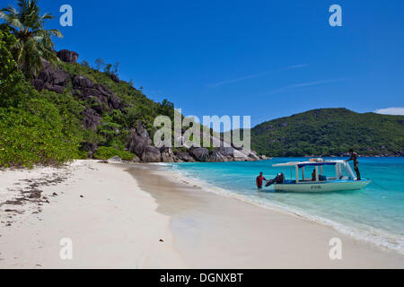 Ausflugsschiff auf dem Strand Anse du Riz an der Baie Ternay Marine Nationalpark, Northern Mahe, Insel Mahe, Seychellen Stockfoto