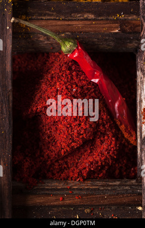 Draufsicht auf red hot Chili peppers und Boden Paprika in alte Holzkiste Stockfoto