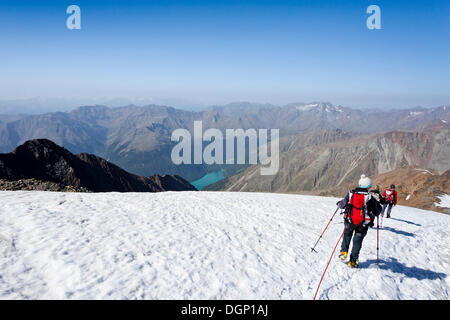 Wanderer vom Similaun Berg, am Niederjochferner Gletscher im Schnalstal-Tal über die Fernagt-reservoir Stockfoto