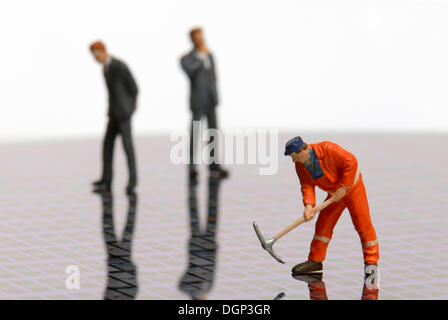 Ein Bauarbeiter und zwei Geschäftsleute Figuren stehen auf einem Silizium-Wafer, elektronisches Bauteil, Halbleiter-Platte, Stockfoto