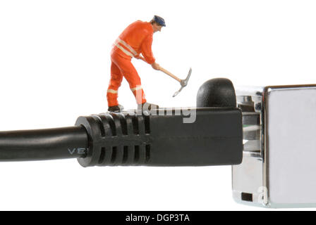 Miniatur-Abbildung eines Bauarbeiters auf ein LAN-Kabel, symbolisches Bild für LAN bei der Arbeit Stockfoto