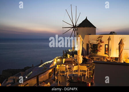 Gäste genießen den Sonnenuntergang auf der Terrasse ein Restaurant, Oia, Santorini, Kykladen, Griechenland, Europa Stockfoto