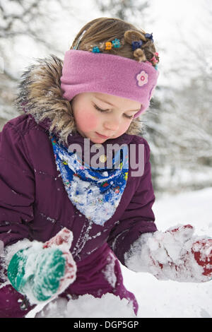 Kleine Mädchen spielen im Schnee Stockfoto