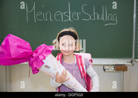 Mädchen mit einem Kegel von Süßigkeiten an ihrem ersten Tag der Schule Stockfoto