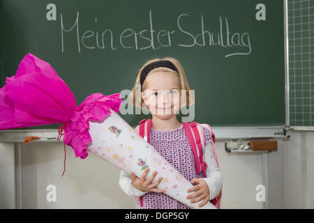 Mädchen mit einem Kegel von Süßigkeiten an ihrem ersten Tag der Schule Stockfoto