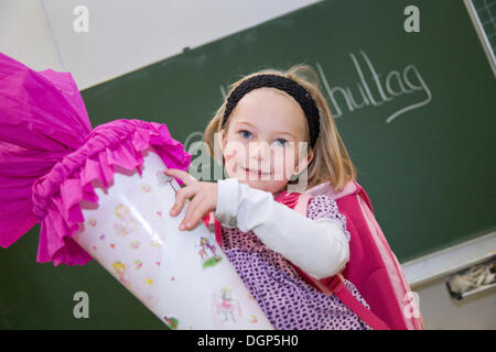 Mädchen mit einem Kegel von Süßigkeiten an ihrem ersten Tag der Schule Stockfoto