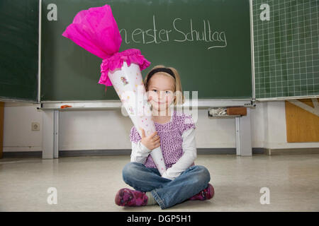 Mädchen mit einem Kegel von Süßigkeiten an ihrem ersten Tag der Schule Stockfoto