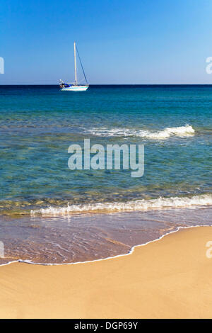 Segelboot vorbei Spiaggia Sa Colonia am Strand an der Costa del Sud, Provinz Sulcis, Sardinien, Italien, Europa Stockfoto