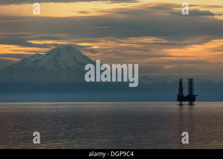 Öl- und Gasplattform in Cook Inlet mit schneebedeckten Bergen Stockfoto