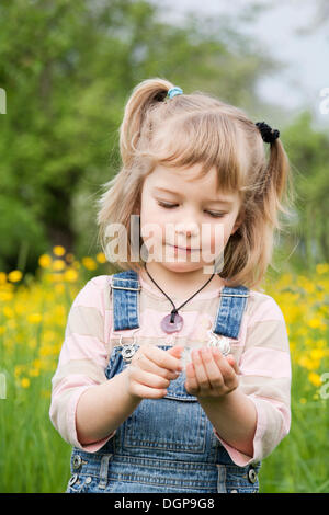 Mädchen zu Fuß durch eine Blumenwiese Stockfoto