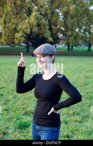 Junge Frau mit Kappe und Zeigefinger index Stockfoto