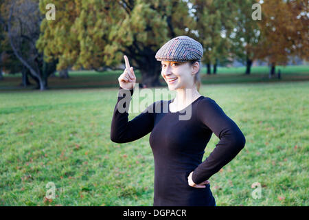Junge Frau mit Kappe und Zeigefinger index Stockfoto