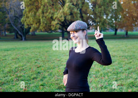 Junge Frau mit Kappe und Zeigefinger index Stockfoto
