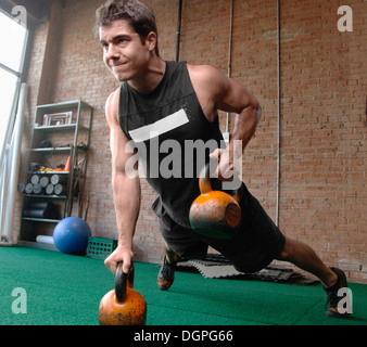 Männlichen Bodybuilder heben kettlebells Stockfoto