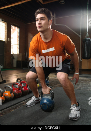 Bodybuilder, die Aufhebung von Kettlebells in Turnhalle Stockfoto