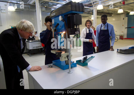 Greenwich London, UK. 24. Oktober 2013. Boris Johnson Uhren ein Student eine Maschine bei der Eröffnung einer neuen technischen Schule betreiben. HRH Prinz Andrew The Duke of York eröffnet ein neues Technikum an der technischen Universität in Royal Borough of Greenwich die Ingenieur- und Fähigkeiten für 14-18 Jahre zur Verfügung stellt, die alte Schüler/-innen sollen ihre Berufsaussichten zu verbessern. Er kam vom Londoner Bürgermeister Boris Johnson und Cllr Chris Roberts und Herrn Baker Gründer des Baker Dearin Trust Stockfoto