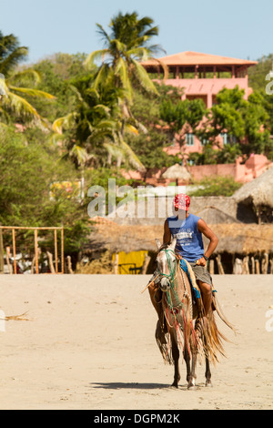 Ein Mann auf einem Pferd am Strand von La Boquita, Nicaragua. Stockfoto