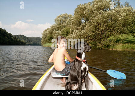 Junge, Paddeln im Kanu, mit seinem Jagdhund Mischling Stockfoto