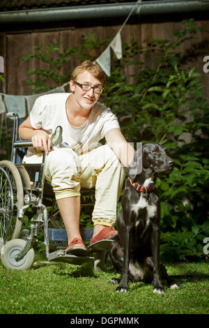 Teenager sitzen im Rollstuhl, mit Begleithund, Therapiehund Stockfoto