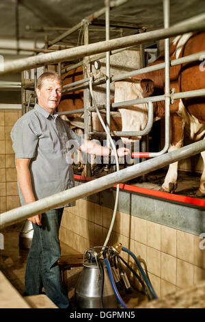 Bauer stand vor den Melkstand Stockfoto