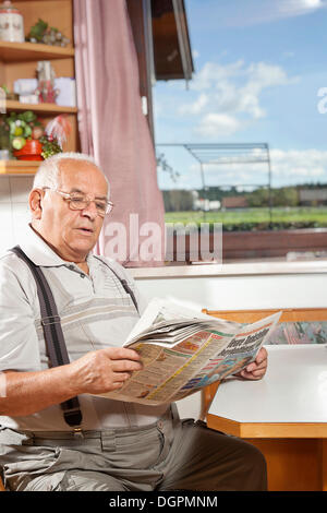 Älterer Mann liest Zeitung Stockfoto