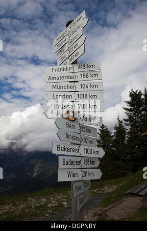 Wegweiser zeigen Wege zu verschiedenen internationalen Städten nahe dem Gipfel des Berges Buchensteinwand, Tirol, Österreich, Europa Stockfoto