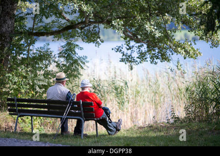 Älteres Ehepaar sitzt auf einer Bank am See, Weißensee, Kärnten, Austria, Europe Stockfoto