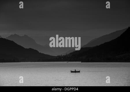 Blick in Richtung Techendorf Weißensee im Abendlicht, mit einem Fischer in einem Ruderboot an der Front, Weißensee Stockfoto