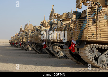 Eine Reihe von britischen Armee gepanzerte Kettenfahrzeuge aufgereiht in Afghanistan zu Weihnachten mit roten Strümpfen von ihnen hängen. Stockfoto