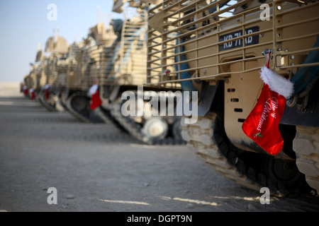 Eine Reihe von britischen Armee gepanzerte Kettenfahrzeuge aufgereiht in Afghanistan zu Weihnachten mit roten Strümpfen von ihnen hängen. Stockfoto