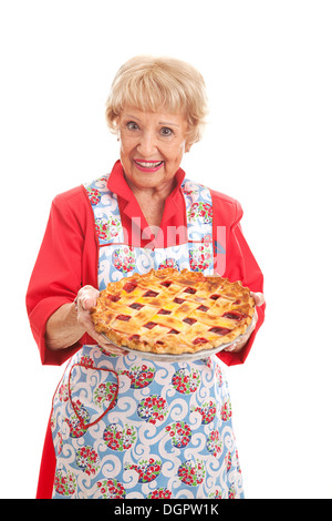 Süße Großmutter hält eine köstliche hausgemachte Kirschkuchen. Retro-Look, isoliert auf weiss. Stockfoto