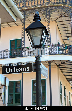 Einen Laternenpfahl und schmiedeeisernen Balkonen an der Ecke von Orleans und Dauphine Street im French Quarter von New Orleans Stockfoto