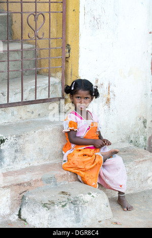 Indische niedriger Kaste Kleinkind Mädchen sitzt auf einem Haus Schritt.  Andhra Pradesh, Indien Stockfoto