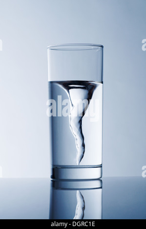 Glas mit Quellwasser auf blauem Grund Stockfoto