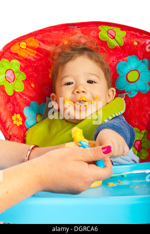 Glückliches Baby Essen Gemüse-Püree und sitzen auf Stuhl Stockfoto