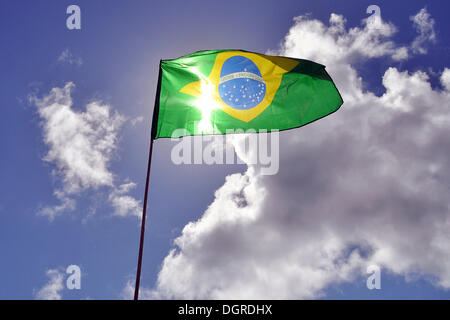 Brasilianische Flagge gegen einen blauen Himmel mit Wolken, Südamerika Stockfoto