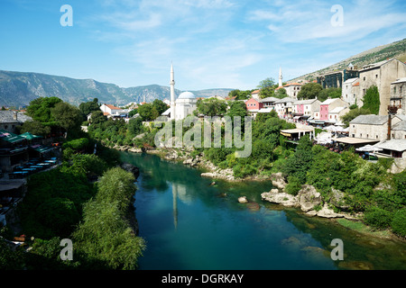 Stadt von Mostar auf Neretva Fluss mit Koski Mehmed Pasa Moschee, Blick von der alten Brücke Stockfoto