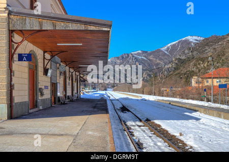 Schienen bedeckt mit Schnee leeren Bahnsteig am kleinen Bahnhof in den Bergen entlang. Stockfoto