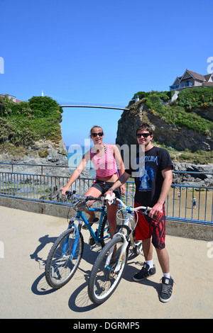 Junges Paar mit Fahrrädern durch Towan Beach, Newquay, Cornwall, England, Vereinigtes Königreich Stockfoto