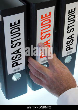 Hand Griff nach einer Dateiordner mit der Bezeichnung "PISA-Studie", Deutsch für "Programme for International Student Assessment, PISA" Stockfoto