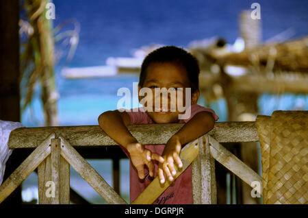 Filipino Junge stand auf einem Geländer, Balicasag Island, Philippinen Stockfoto