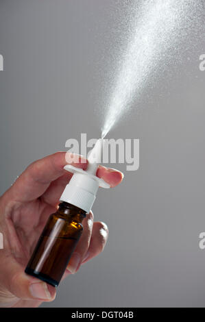 Sprühen Sie aus einem Nasenspray in einer braunen Glasflasche Stockfoto